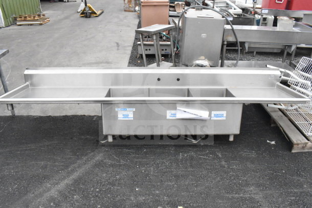 Commercial 3 bay sink with dual drain boards, no legs. Stainless steel, labels for wash, rinse, sanitize visible.
