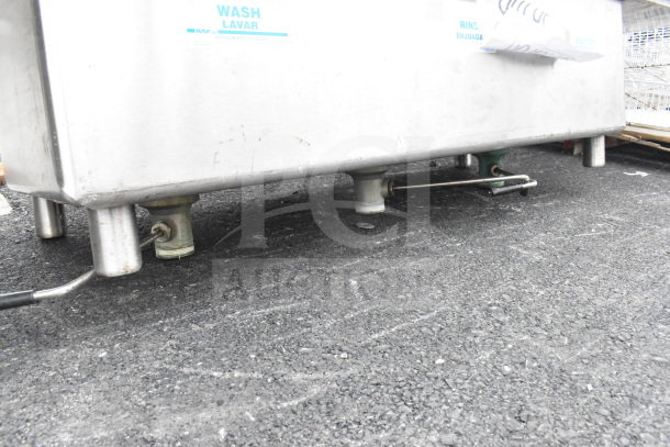 Commercial 3 bay sink with dual drain boards, no legs. Stainless steel, with visible wear. Markings include "WASH" and "RINSE."