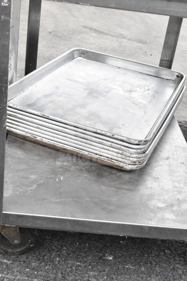 3 tier chrome finish cart with contents including stacked baking trays. Visible wear, sturdy metal construction.