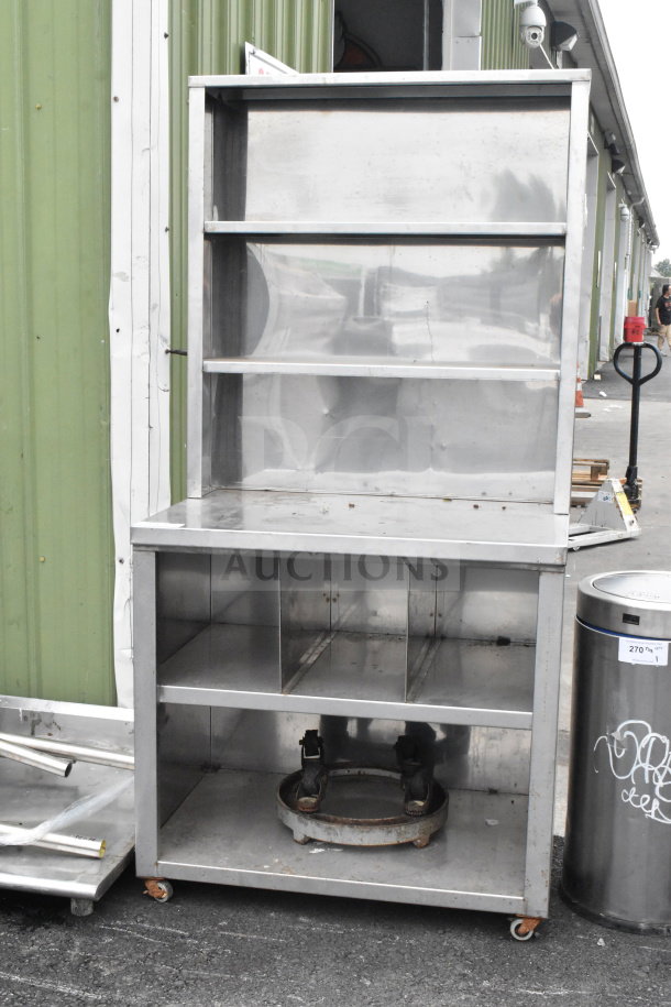 Commercial counter with two over shelves and two under shelves on commercial casters, stainless steel, good condition.