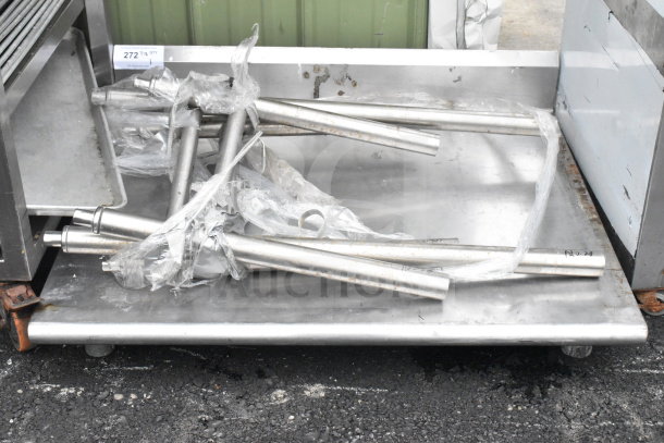 Commercial table with metal legs, unassembled, on a flatbed. Includes packaging. Condition appears used.