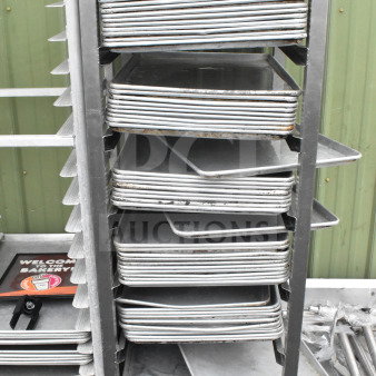 Commercial pan transport rack on casters with 50 baking pans. Includes metal construction and tag indicating item number 273.