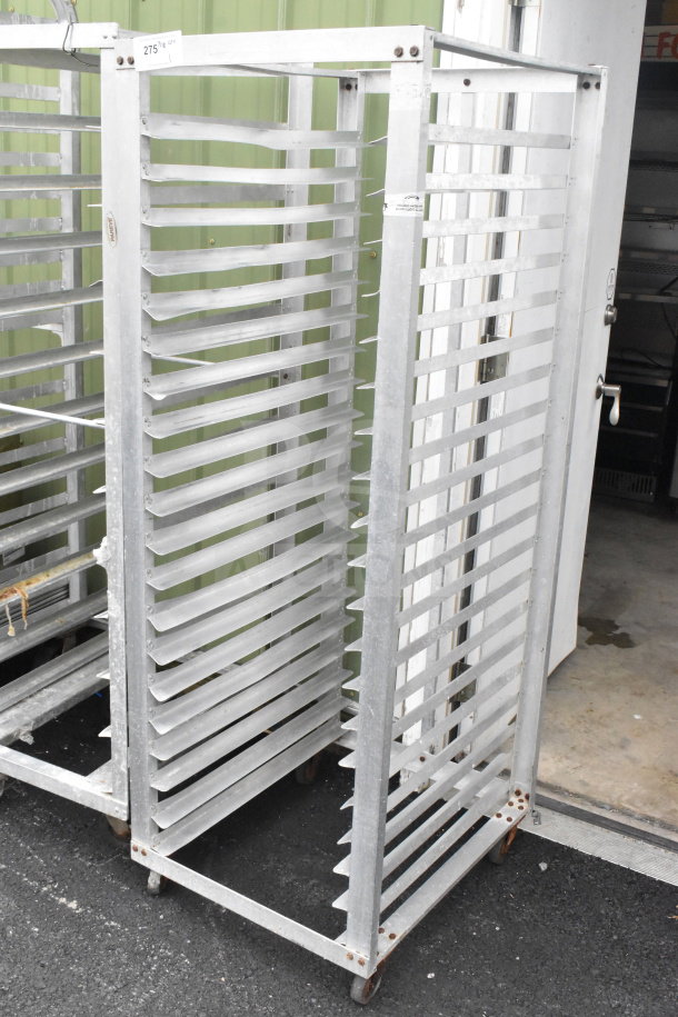 Commercial pan transport rack with multiple shelves, mounted on sturdy commercial casters, in used condition.