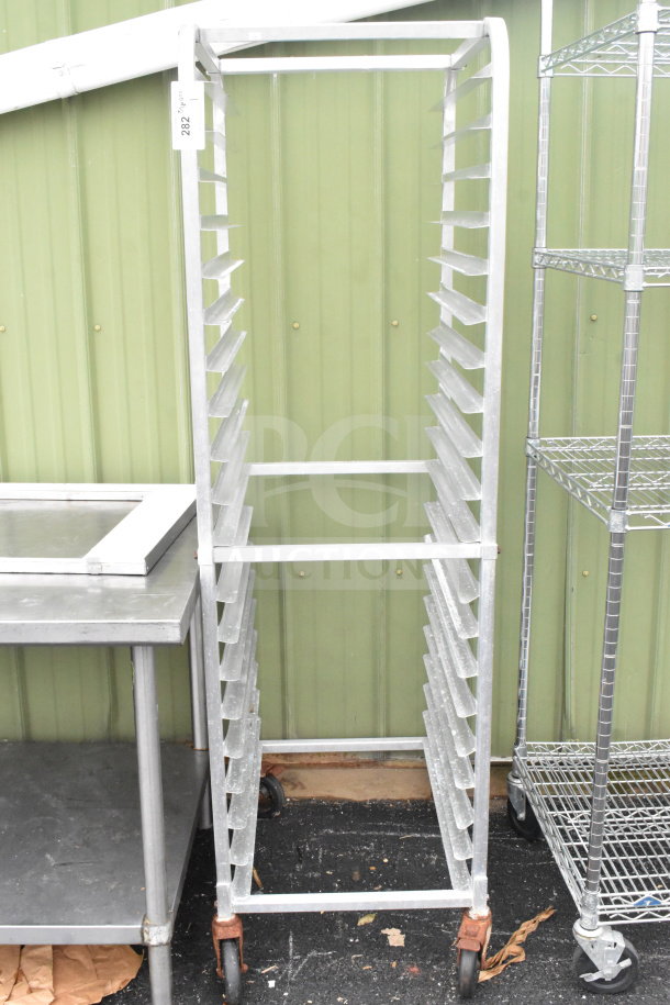 Commercial pan transport rack with multiple slots, on sturdy commercial casters. Good condition, metal construction, item tag 282.