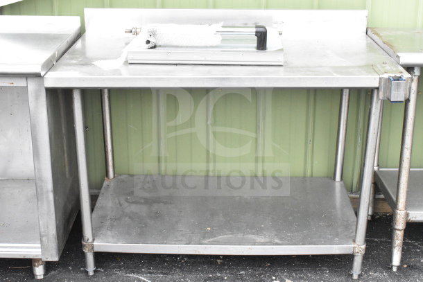 Commercial stainless steel table with under shelf, mounted can opener, and oven door accessory; used condition.