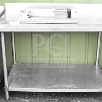 Commercial stainless steel table with under shelf, mounted can opener, and oven door accessory; used condition.