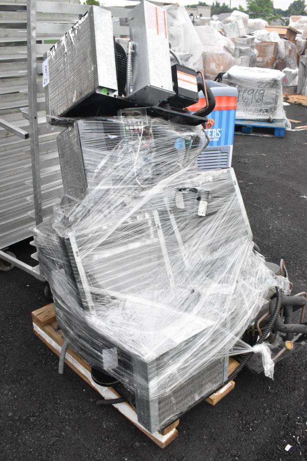 Seven compressors, including Copeland, bundled and wrapped on a pallet; visibly used, with factory and safety labels.