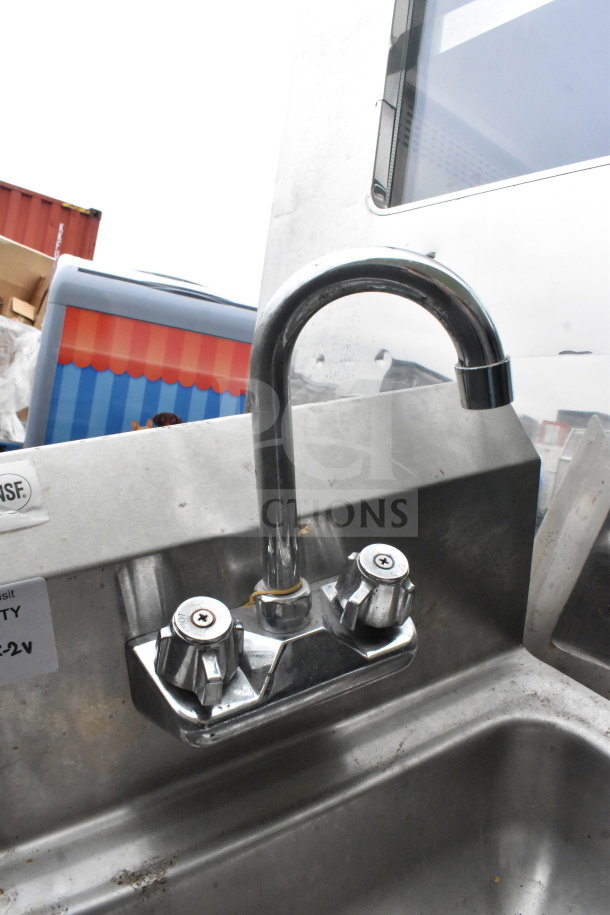 Stainless steel wall mount sink with Regency 600HS17 faucet, two knobs, NSF certified, used condition, visible wear.