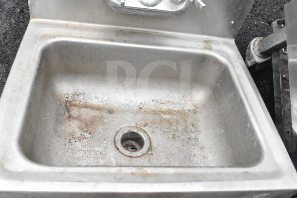 Stainless steel single bay wall mount sink, includes Regency 600HS17. Visible wear and rust. Suitable for utility use.