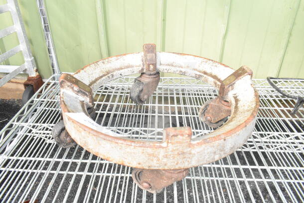 Commercial mixing bowl dolly with swivel casters. Metal frame with visible wear and rust. Suitable for heavy-duty use.