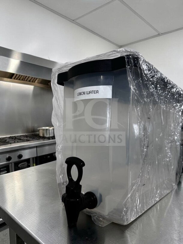 Like-new plastic cold juice dispenser with spigot; labeled "Lemon Water"; countertop ready, unbranded model MIS-S-DISP-1227.