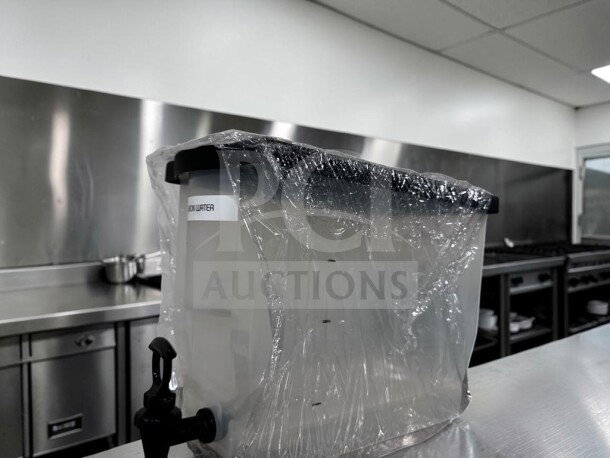 Plastic cold juice dispenser with spigot, like-new condition, ready for use, wrapped in protective plastic, labeled "COLD WATER."