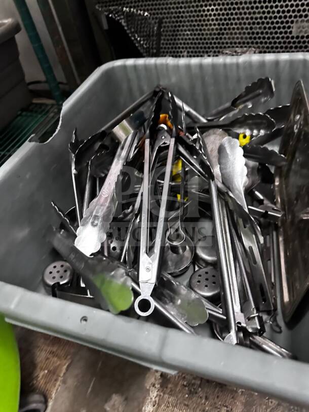 Mixed commercial kitchen utensil lot in gray container with tongs, spatulas, and ladles; well-maintained, ideal for restaurant use.