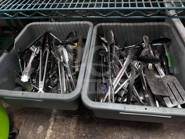 Two containers with mixed commercial kitchen utensils including tongs, spatulas, and ladles, well-maintained, ready for use.