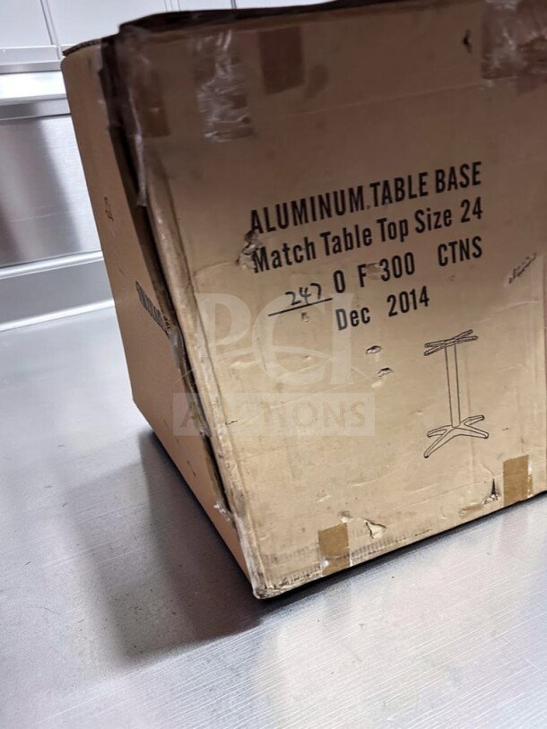 Box containing new aluminum table base for 24" tabletop, commercial use. Labeled "Aluminum Table Base, Match Table Top Size 24."