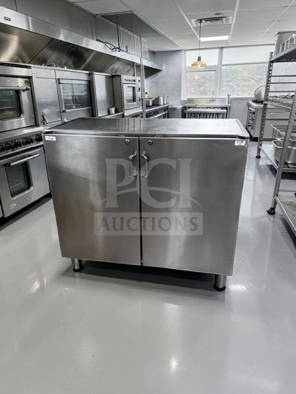 Commercial stainless steel storage cabinet, 48" wide, dual locking swing doors, heavy-duty worktop, well-maintained condition.