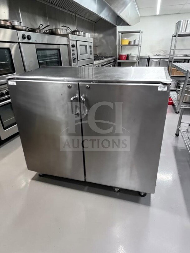 Commercial stainless steel storage cabinet, 48" wide, dual locking swing doors, heavy-duty worktop, well-maintained.
