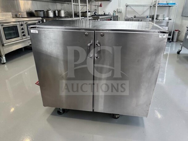 Commercial stainless steel storage cabinet with dual locking swing doors, 48" wide, heavy-duty worktop, well-maintained.