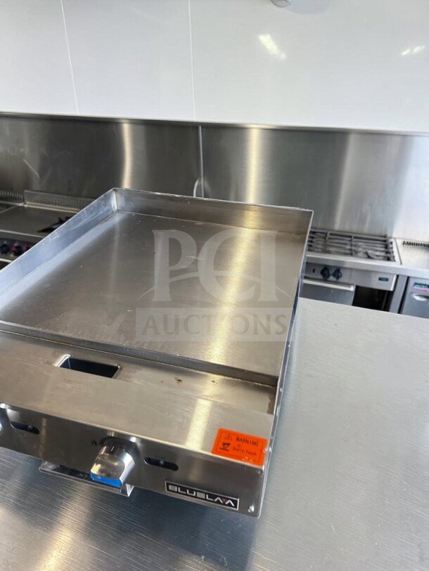 Pristine 24" Blue Lava BLGM24-24D gas griddle, 60,000 BTU, 1" plate, new condition, CSA certified, visible control knob.