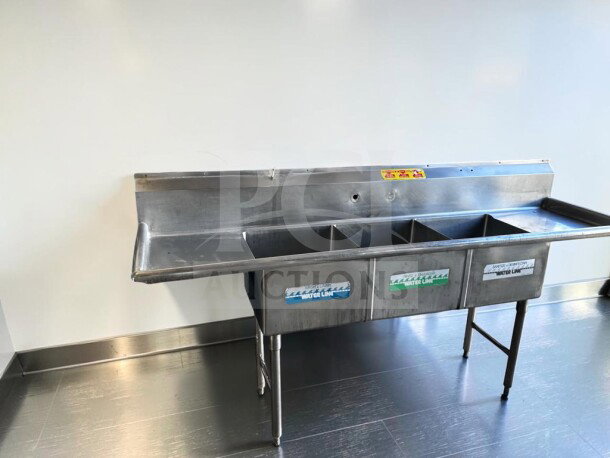 Flawless three-compartment stainless steel sink with dual drainboards, high backsplash, and adjustable legs, inspected.
