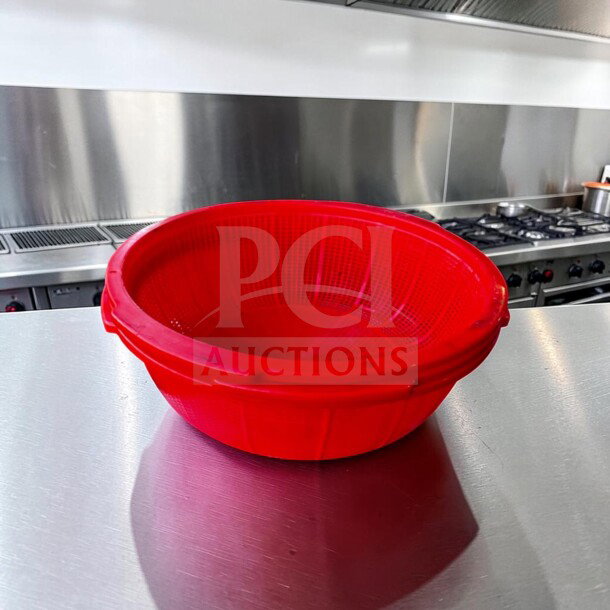 Red 20" plastic colander basket in pristine condition with integrated handles, ideal for large-capacity straining.