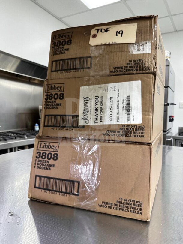 Stacked boxes of 36 new Libbey 3808 16 oz. Belgian beer glasses, labeled as customizable and dishwasher safe.