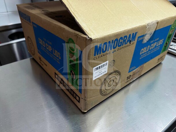 Cardboard box labeled "Monogram Cleaning Disposables" containing 1,000 compostable cold cup lids. New condition.