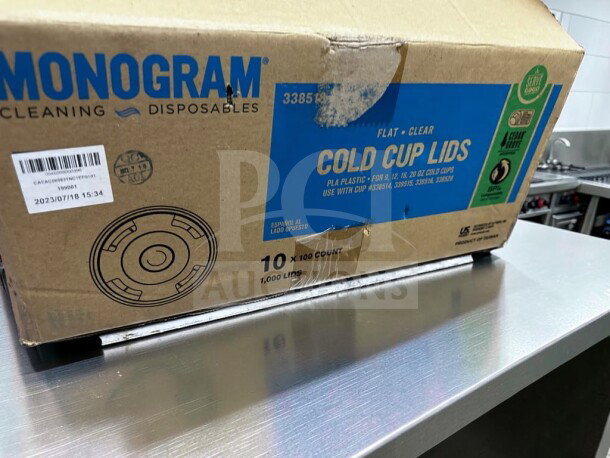 Box of Monogram Serve Good 1,000 compostable cold cup lids, fits 9-20 oz cups, straw slot, pristine condition, model number partially obscured.