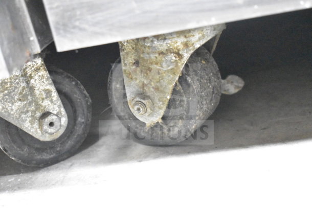 Close-up of one caster wheel on the Taylor C723-33 commercial soft serve ice cream machine, showing wear and some rust.