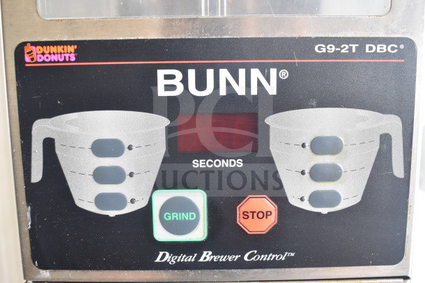 Bunn G9-2T coffee grinder control panel showing grind and stop buttons, digital display, and brand logo.