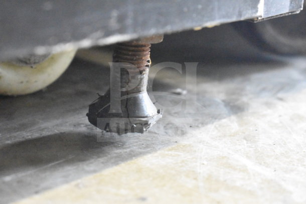 Close-up of Sanye Commercial Open Grab N Go Merchandiser leg, showing signs of wear and rust.