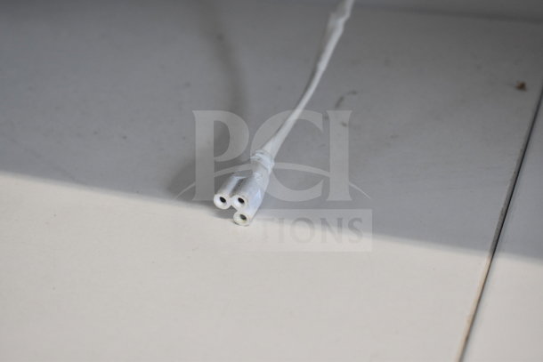 Cable connector from Sanye Grab N Go Merchandiser, white, showing a three-hole design. Marks of usage visible.