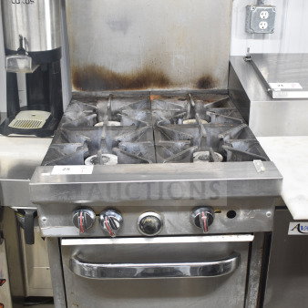 Southbend commercial gas-powered 4 burner range with oven, overshelf, and backsplash. Visible wear on burners and oven door.