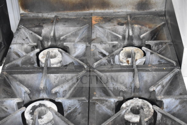 Southbend commercial gas 4-burner range with oven, overshelf, and back splash on casters. Condition shows signs of use.