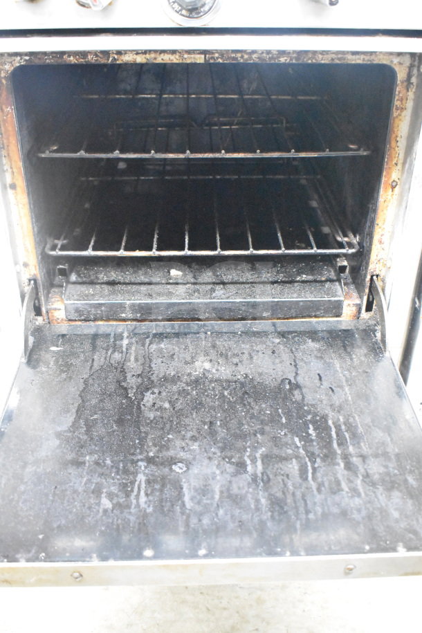 Southbend commercial gas oven's interior, showing two wire racks and signs of wear, part of a 4-burner range unit.