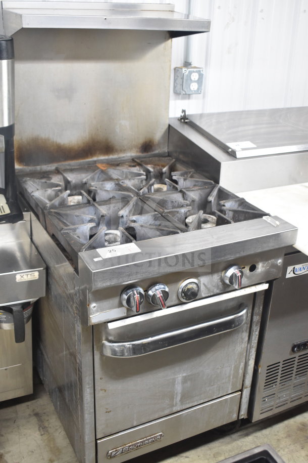 Southbend commercial gas stove with 4 burners, oven, over-shelf, backsplash, and casters. Used condition, stainless steel.