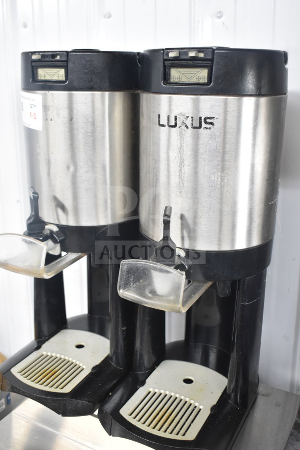 Two Fetco Luxus L3D-10 hot beverage dispensers in stainless steel, visible wear, with spouts and drip trays.