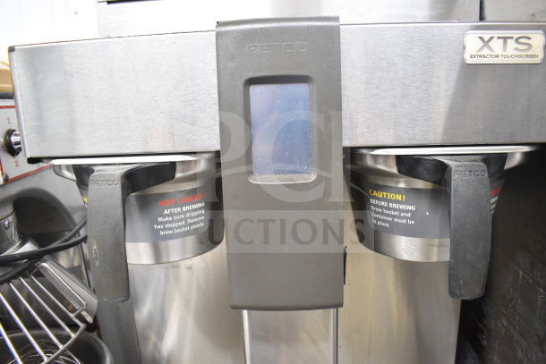 XTS Commercial Coffee Machine, dual brew baskets, hot water dispenser, touchscreen, steel finish, visible caution labels.