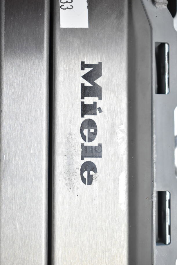 Miele undercounter dishwasher, stainless steel finish, 115 volts, 1 phase, slight surface wear, visible brand logo.