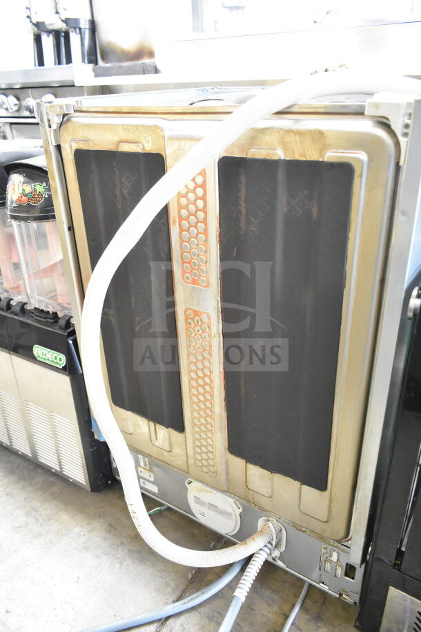 Miele undercounter dishwasher, 115 volts, 1 phase, shown from the back with exposed hoses and panels. Good condition.