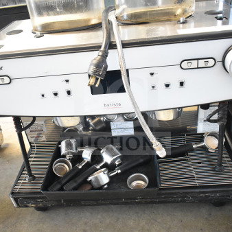 Schaerer Barista commercial 2-group espresso machine with 2 hoppers, 4 portafilters, and 2 steam wands; power cord visible.