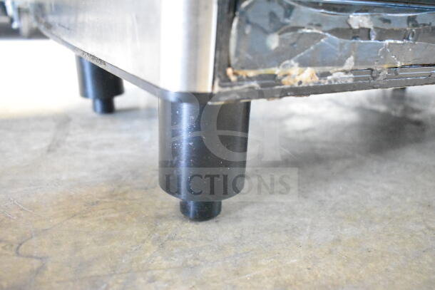 Schaerer Barista espresso machine base detail; black leg, visible wear on metal indicating used condition.