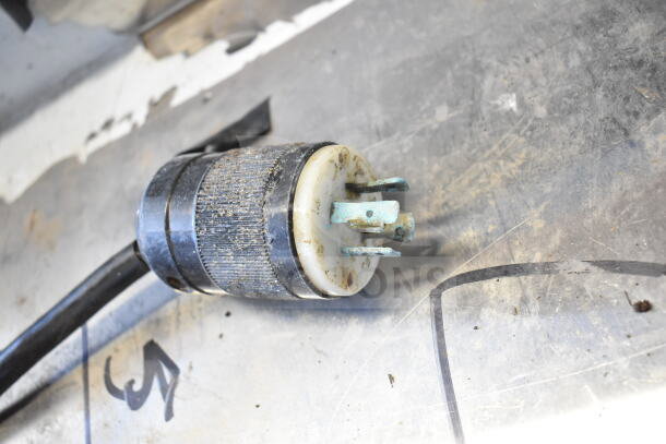 Close-up of a power plug from the Sirman TC 32 MONTANA E meat grinder, showing wear and some corrosion on the prongs.