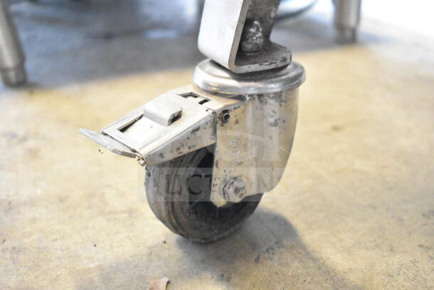 Sirman TC 32 MONTANA E meat grinder caster wheel detail, showing wear. Industrial-grade, 220V, 3-phase electric model.