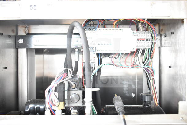 Chicago vertical style compactor interior with visible wiring and components, mounted on commercial casters.