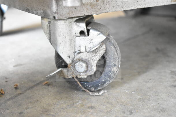 Chicago Commercial Vertical Style Compactor on caster. Visible wear on caster, enhancing mobility. Model details not shown.