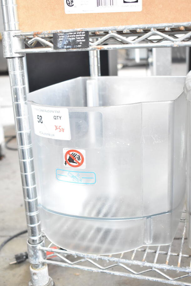 Transparent hopper for a drink blending machine, placed on a metal rack. Item tag reads "58 QTY X-5v."
