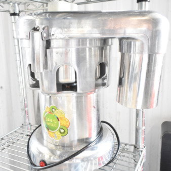 Commercial countertop citrus juicer, stainless steel, 110 volts, 1 phase. "100% natural" label on front.