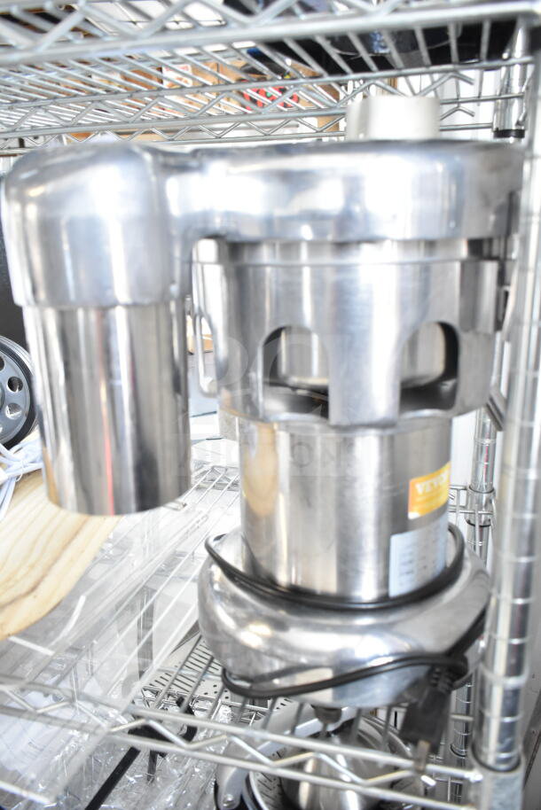 Commercial countertop citrus juicer, stainless steel, 110 volts, 1 phase, in good condition, on a metal rack.