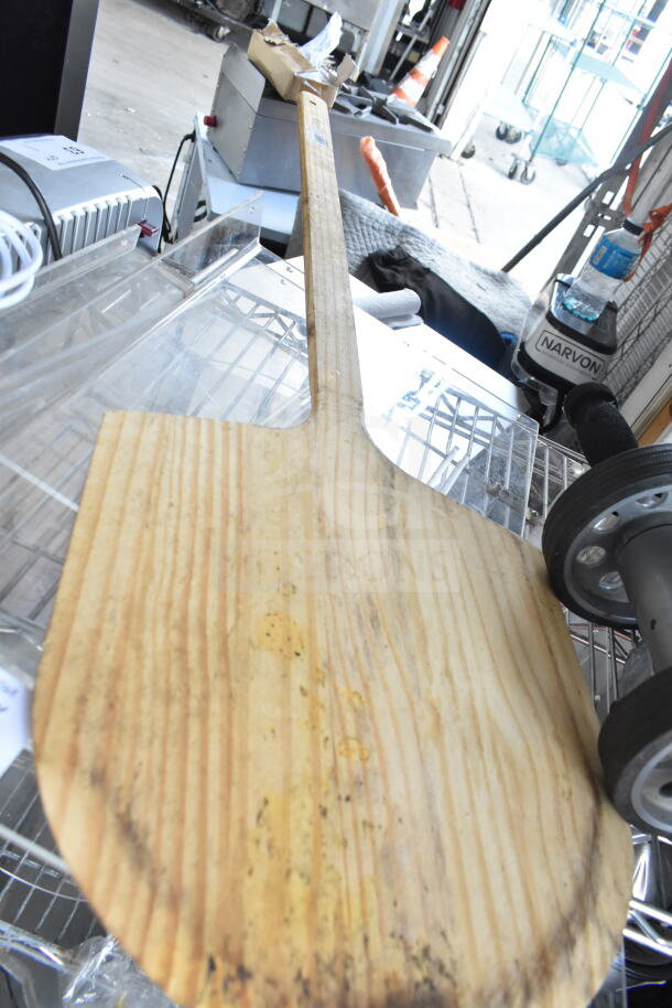Wooden pizza paddle, rustic condition, alongside a rolling unit; part of a 7-item auction lot.
